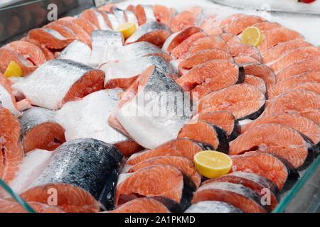 Salmone fresco di bocconcini e bistecche sul ghiaccio nel negozio di alimentari Foto Stock