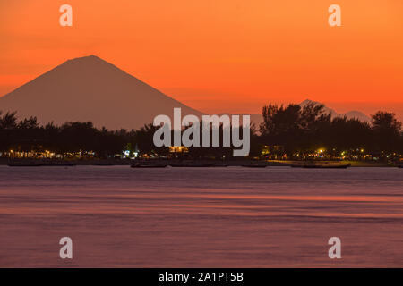 Gili Trawangan come si vede dal Gili Meno con il Monte Agung in background, Bali Indonesia dopo il tramonto. Foto Stock