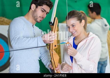 Giovane donna sorridente holding archer bow Foto Stock