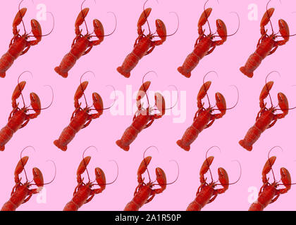 Recentemente bollita e aragoste rosso in configurazione su sfondo rosa. Immagine Foto Stock