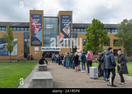 Muovendosi in giornata presso l'Università del Surrey in Guildford, Inghilterra, Regno Unito. I nuovi studenti che arrivano sul campus il 28 settembre 2019 in fila al ritiro della chiave Foto Stock