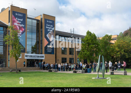 Muovendosi in giornata presso l'Università del Surrey in Guildford, Inghilterra, Regno Unito. I nuovi studenti che arrivano sul campus il 28 settembre 2019 in fila al ritiro della chiave Foto Stock