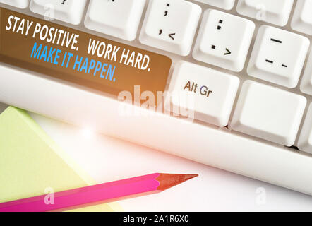 La scrittura della nota mostra Rimanere positivo lavorare duro farlo accadere. Il concetto di business per ispirazione motivazione atteggiamento White tastiera PC con nota paper ab Foto Stock