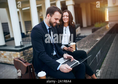 Giovani positivo co-lavoratori aventi il resto, gioia, vacanze weekend, l uomo e la donna ha trovato client, sponsor Foto Stock