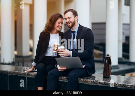 Overjoyed giovani in smart vestiti raccontare barzellette a ciascun altro, vicino fino foto,felicità Foto Stock