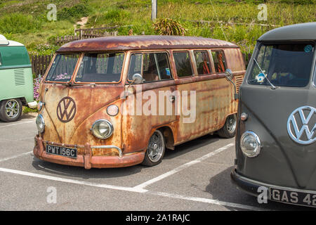 Righe del Classico Volkswagen camper parcheggiato a Porthtowan spiaggia parcheggio sul West Cornwall coast, Inghilterra, Regno Unito. Foto Stock