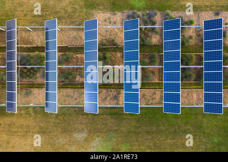 Drone vista dall'alto in basso del giardino di lavanda e sulla parte superiore dei pannelli solari in linea durante il giorno d'estate. Le fonti di energia rinnovabili e il giardinaggio ecologico Foto Stock