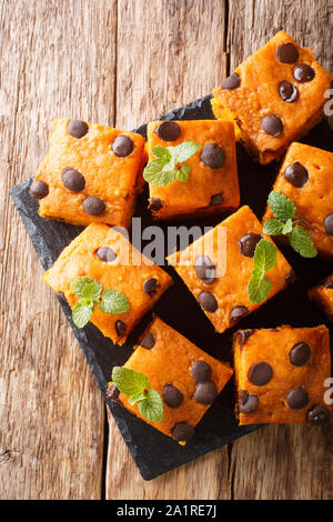 Deliziosi blondies di zucca con cioccolato e menta close-up su una scheda di ardesia sul tavolo. Verticale in alto vista da sopra Foto Stock