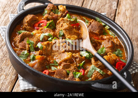 Carni di agnello disossate slow cotti con yogurt e indiani tradizionali spezie caldi close-up in una padella sul tavolo orizzontale. Foto Stock