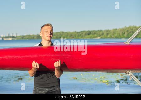 Ragazzo adolescente con sport barca kayak, teens camminando con la barca nel loro bracci di fiume, sport acquatici, attiva un sano stile di vita dei giovani maschi Foto Stock