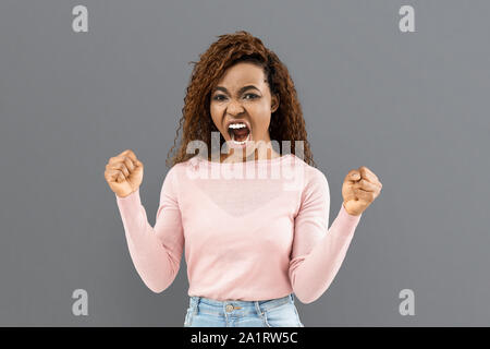 Molto turbato arrabbiato donna urlando e stringendo la sua a suon di pugni Foto Stock