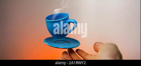 Blu flottante tazzina di caffè espresso con le mani. Visuale in prima persona. Mock up di volare in aria tazza di caffè caldo. Levitare concept Foto Stock