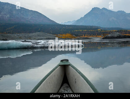 Pagaiando tra gli iceberg del ghiacciaio Matanuska su un grigio e triste giorno, foglie dorate aggiungere il colore in distanza. Foto Stock