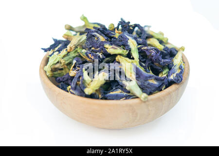 Essiccato butterfly pea sulla ciotola legno isolato su sfondo bianco con tracciato di ritaglio Foto Stock