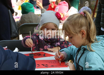 Kiev, Ucraina. 28 Sep, 2019. I bambini cercano di scrivere i caratteri cinesi durante una manifestazione culturale di Kiev, in Ucraina, il 7 settembre 28, 2019. Un evento culturale intitolato "insolito Viaggio in Cina", che è stato organizzato dalla città di Kiev governo e dedicata al settantesimo anniversario della fondazione della Repubblica popolare cinese, ha avuto luogo in uno dei Central Kiev parchi della capitale dell'Ucraina di sabato. Credito: Sergey Starostenko/Xinhua/Alamy Live News Foto Stock