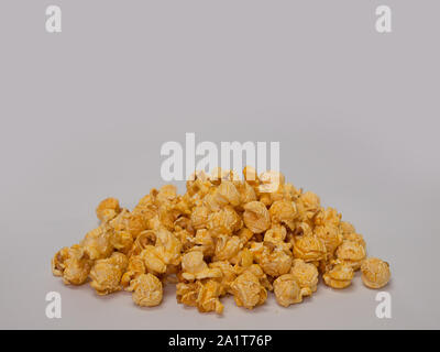 Dolce caramello popcorn ,posto su uno sfondo bianco. Foto Stock