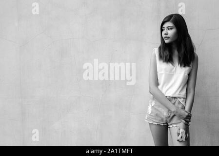 Bella ragazza adolescente pensando all'aperto girato in bianco e nero Foto Stock