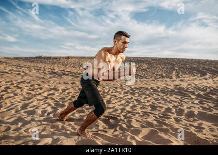 Atleta sulla esecuzione di allenamento nel deserto a giornata di sole Foto Stock