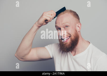 Carino lieto uomo positivo in bianco shirt casual pettinare capelli isolat Foto Stock