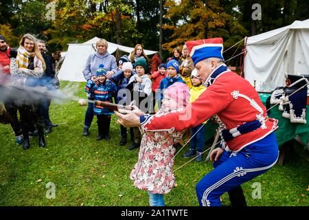 Mosca, Russia. 28 Sep, 2019. Un bambino cerca la cottura di un palazzo del XIX secolo pistola durante la "Guerra e Pace" festival tenutosi a Ostafievo manor all'estrema periferia di Mosca, Russia, Sett. 28, 2019. L idea di questo festival è stato quello di ricreare l'atmosfera della prima metà del XIX secolo in Russia. Il nome del festival si riferisce al libro "Guerra e Pace" di Lev Tolstoj che descritto in questo periodo della storia russa. Credito: Maxim Chernavsky/Xinhua/Alamy Live News Foto Stock