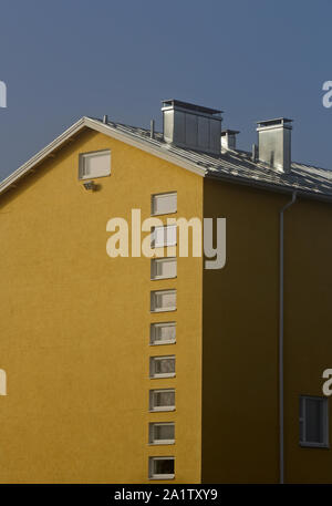 Un alto edificio scolastico con un sacco di finestre in fila. La parete è intonacate e dipinte di giallo Foto Stock