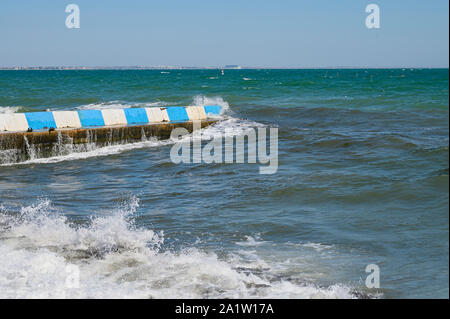 Mar Nero, piccole onde si infrangono sulla scogliera di calcestruzzo. Giornata di sole cielo privo di nuvole Foto Stock