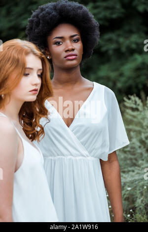 Messa a fuoco selettiva di attraenti African American Girl in piedi vicino a redhead donna Foto Stock