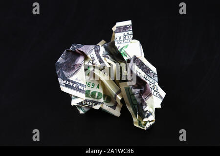 Crumpled un centinaio di dollaro americano su nero lo sfondo della carta, close-up di bad denaro. Il crollo del dollaro. Svalutazione. La caduta di moneta. Foto Stock