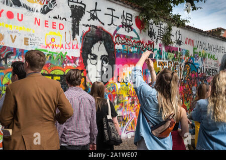 Muro di John Lennon, Praga, Repubblica Ceca. I turisti la visualizzazione di parole e di opere d'arte, Grand Priory Square, Mala Strana di Praga. Foto Stock