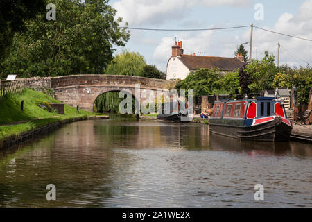 Una stretta barca o chiatta ormeggiata sulla Shropshire Union Canal in Inghilterra, dall'imbarcazione Inn nel villaggio di Gnosall. Foto Stock