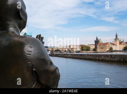 Praga, Repubblica Ceca. L'Armonia statua in ricordo di Sri Chinmoy, affacciato sul fiume Moldava con vecchi edifici del Comune in background. Foto Stock