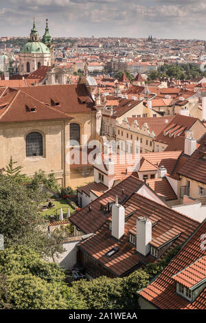 Hradcany e Mala Strana distretti, Praga, Repubblica Ceca. Paesaggio urbano elevati vista guardando ad est verso la cupola verde della chiesa di St Nicholas. Foto Stock