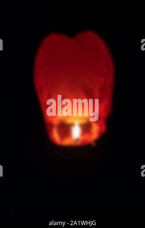 Abstract sfocata l'immagine di sfondo della mongolfiera o sky lantern volare nel cielo di notte. Concetto di stagione festosa celebrazione, Diwali, nuova sì Foto Stock