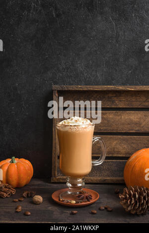 Pumpkin Spice Latte nero su sfondo di legno, copia dello spazio. Stagionale autunnale di bere caffè con spezie e zucche di organico. Foto Stock