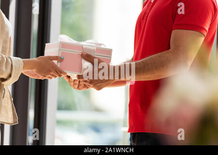 Vista ritagliata della consegna uomo dando rosa presente per donna Foto Stock