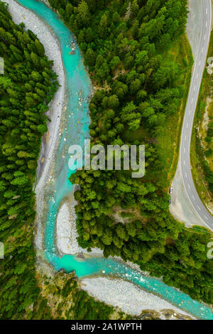 Inn fiume che scorre nella foresta in Svizzera. Vista aerea da fuco su un fiume azzurro in montagna Foto Stock