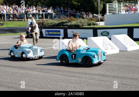 I bambini nel loro vintage Austin J40 pedale come vetture iscritte nel Settrington Cup gara al Goodwood xiv sett 2019 a Chichester, Inghilterra. Foto Stock