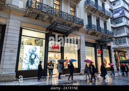 Atene, Grecia - 4 Gennaio 2019: Visualizzazione di una HM store durante la notte con le persone intorno a Atene, Grecia Foto Stock