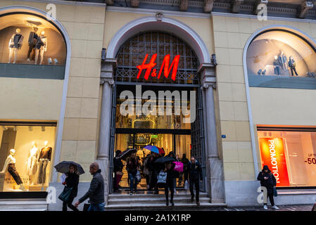 Atene, Grecia - 4 Gennaio 2019: Visualizzazione di una HM store durante la notte con le persone intorno a Atene, Grecia Foto Stock