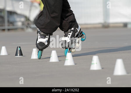 Pattini a rotelle in linea che si muove attraverso un skatepark Foto Stock