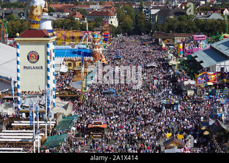 Un grande numero di visitatori di passeggiare in una domenica / weekend lungo uno dei viali principali di Oktoberfest a Theresienwiese, Monaco di Baviera, Germania. Foto Stock