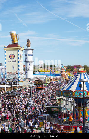 Un grande numero di visitatori di passeggiare in una domenica / weekend lungo uno dei viali principali di Oktoberfest a Theresienwiese, Monaco di Baviera, Germania. Foto Stock