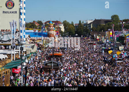 Un grande numero di visitatori di passeggiare in una domenica / weekend lungo uno dei viali principali di Oktoberfest a Theresienwiese, Monaco di Baviera, Germania. Foto Stock