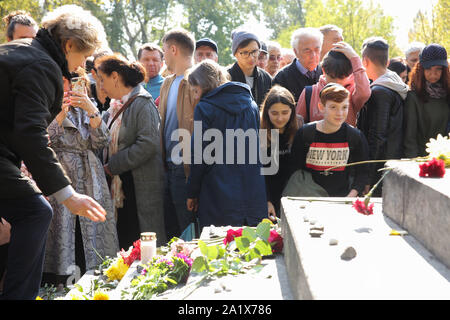 Kiev, Ucraina. 29Sep, 2019. Persone laici pietre ghiaia e fiori per la Menorah memoriale per commemorare più di 33 migliaia di ebrei di Kiev eseguito dai nazisti a Babi Yar 78 anni fa, a Kiev, Ucraina, 26 settembre 2019. Il marzo di ricordo per contrassegnare il 78° anniversario dell'esecuzione di massa di Kiev ebrei in Babi Yar. Credito: Sergii Kharchenko/ZUMA filo/Alamy Live News Foto Stock