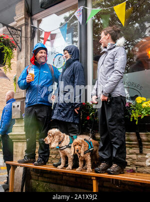 Ventilatori e cani tenendo il coperchio dalla pioggia pesante nella giornata finale di UCI mondiali di ciclismo, Harrogate, Regno Unito, 29 Settembre 2019 Foto Stock