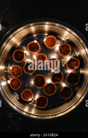 Una piastra è che è caricata con rose e candela su indian festival diwali deepawali con il fuoco isolato sul tavolo Foto Stock