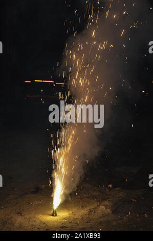 Un vaso è che è caricata con rose e candela su indian festival diwali deepawali con il fuoco isolato sul tavolo Foto Stock