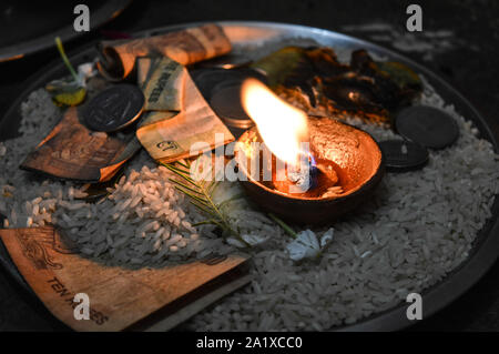 Un vaso è che è caricata con rose e candela su indian festival diwali deepawali con il fuoco isolato sul tavolo Foto Stock