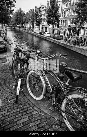 AMSTERDAM, PAESI BASSI,SETTEMBRE, 05, 2019: tramonto in Amsterdam.Il parcheggio per le bici e il tradizionale stile olandese antico di edifici.Il mercato dei fiori sul singolo canale, Antille Foto Stock