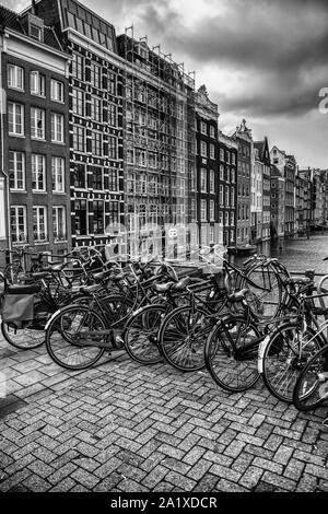 AMSTERDAM, PAESI BASSI,SETTEMBRE, 05, 2019: tramonto in Amsterdam.Il parcheggio per le bici e il tradizionale stile olandese antico di edifici.Il mercato dei fiori sul singolo canale, Antille Foto Stock